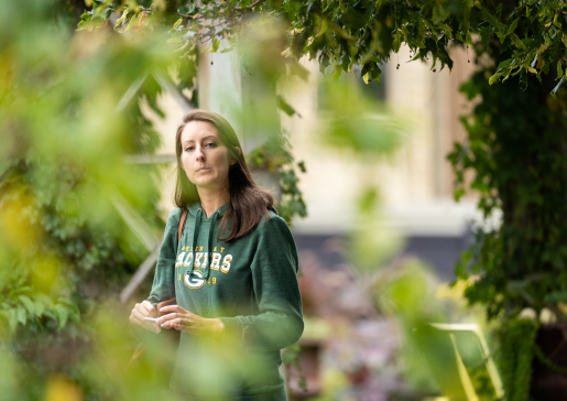 A University of Wisconsin internal medicine resident wearing a Green Bay Packers sweatshirt walks in Allen Centennial Gardens during the Empathy Course