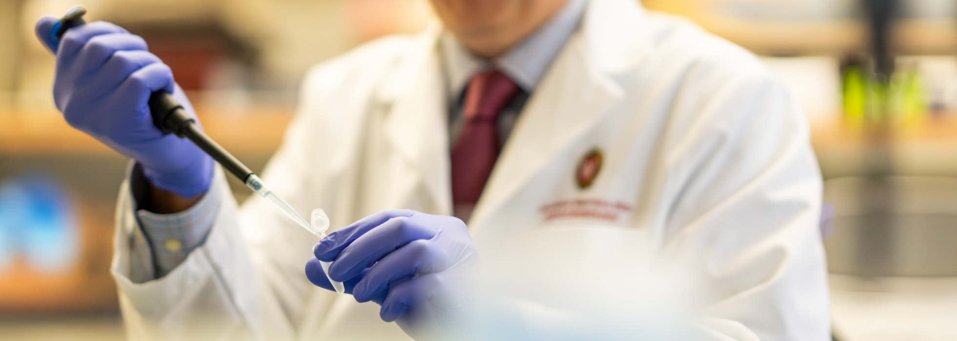 closeup of a male scientist in white lab coat working in the lab