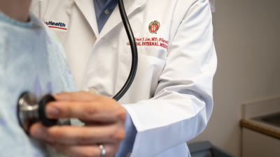 A doctor checks someone's heartbeat.