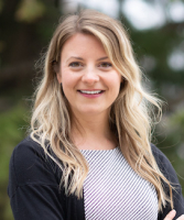 Chief resident Lindsay Matthews, MD, stands outside wearing a grey shirt and black sweater