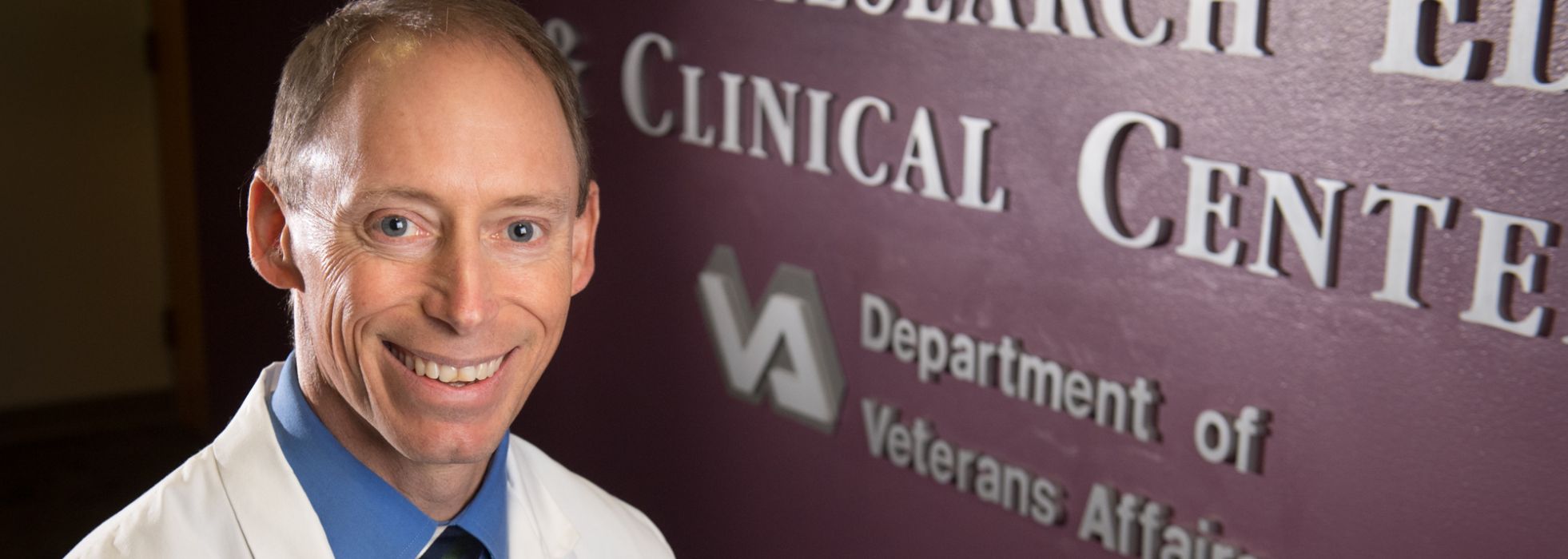 Dr. Steve Barczi in front of the the VA GRECC sign