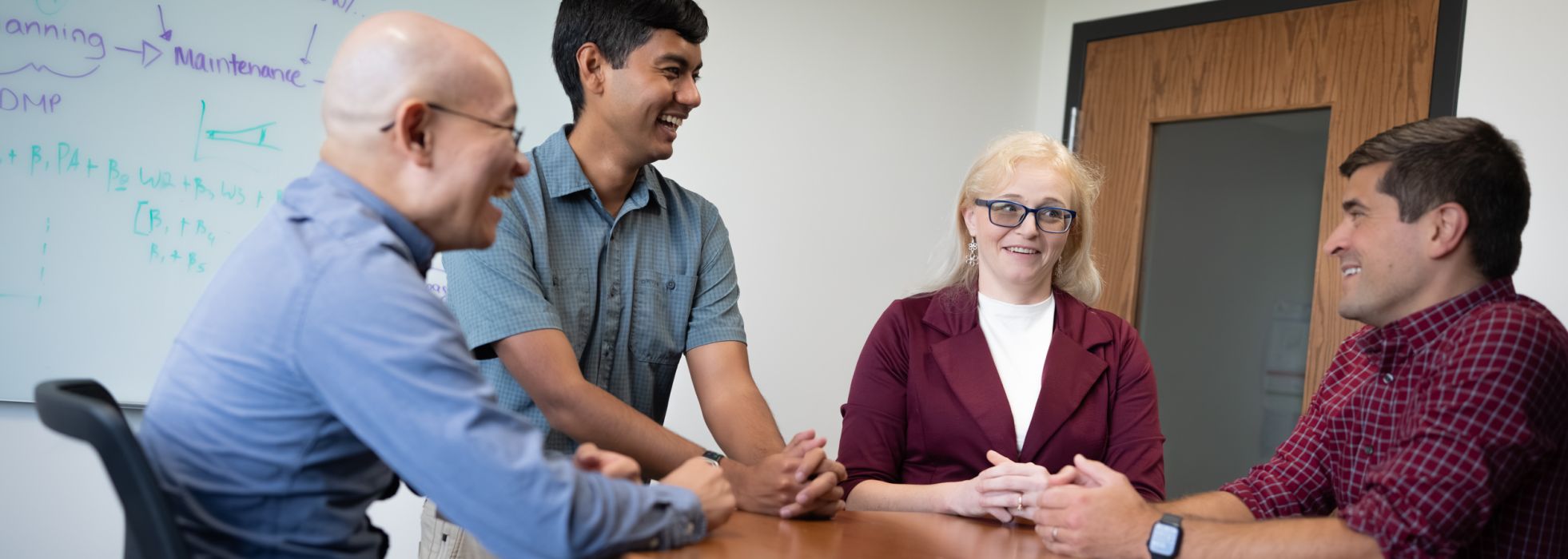 Members of the clinical informatics program talking around a table.