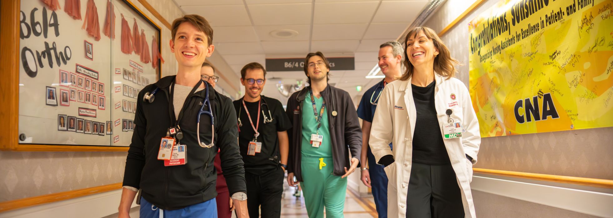 Internal medicine residents and a doctor walking down a hospital hallway