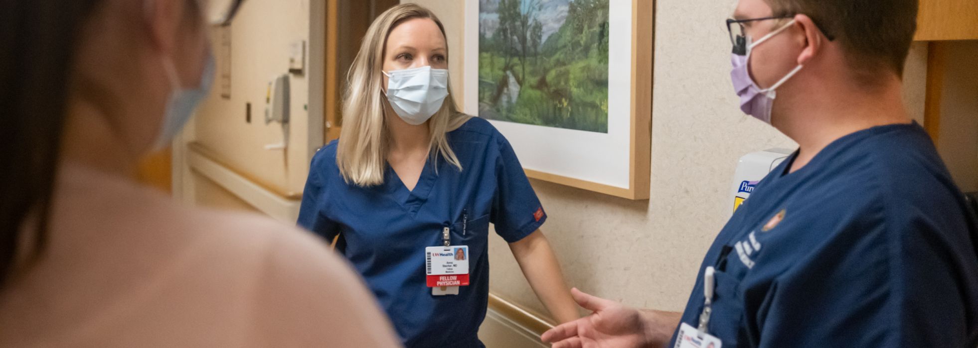 Palliative care fellow and faculty talking in a hospital hallway