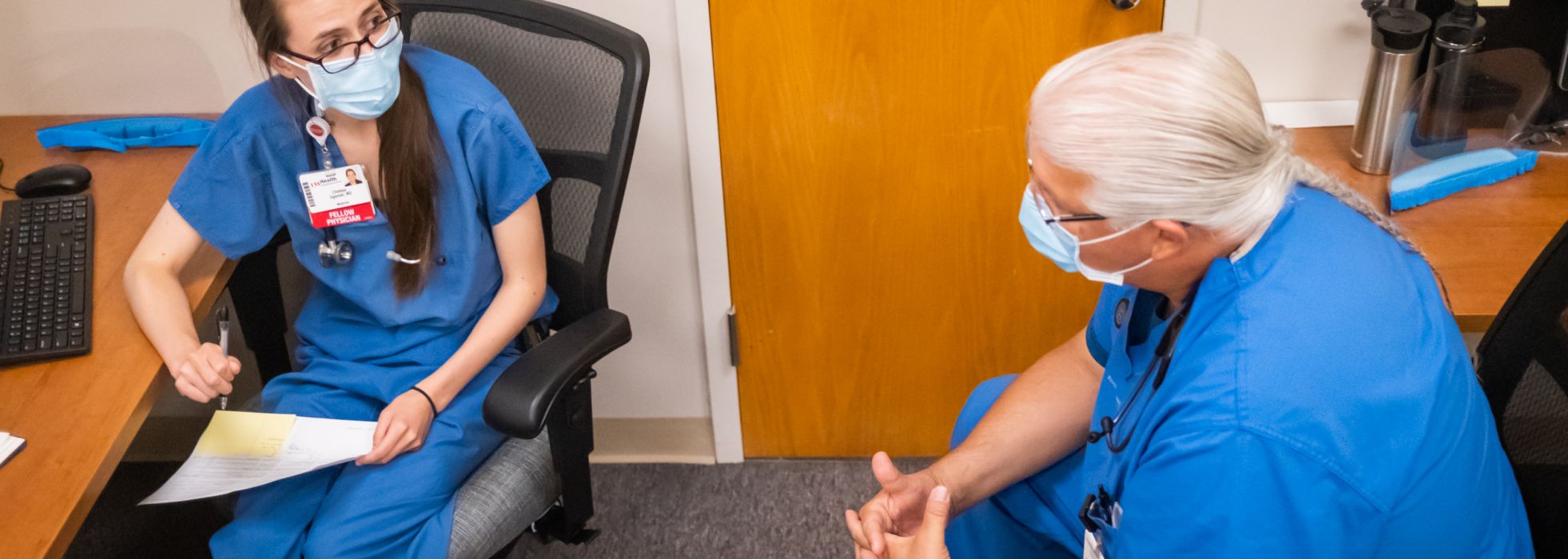 Dr. Bret Benally Thompson talking with a palliative care fellow in clinic