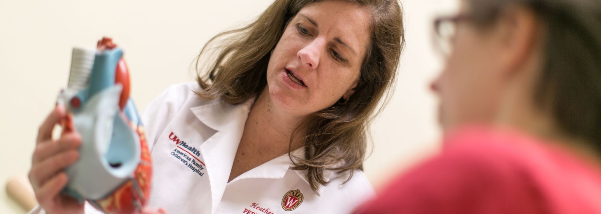 Dr. Heather Bartlett showing heart model to patient