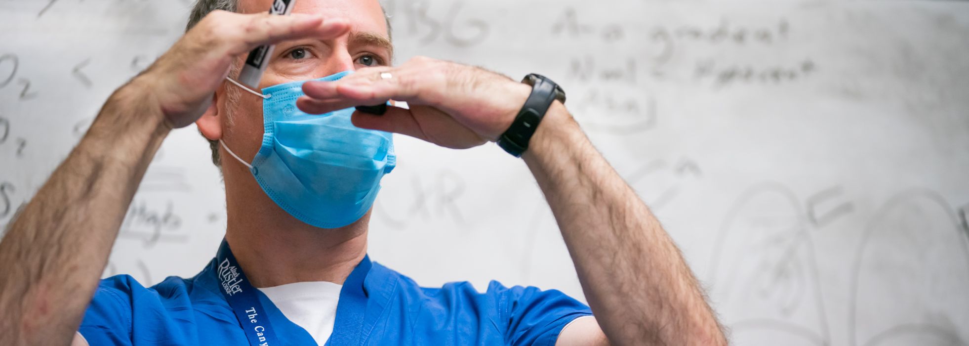 Closeup of Dr. Loren Denlinger in front of a whiteboard teaching residents