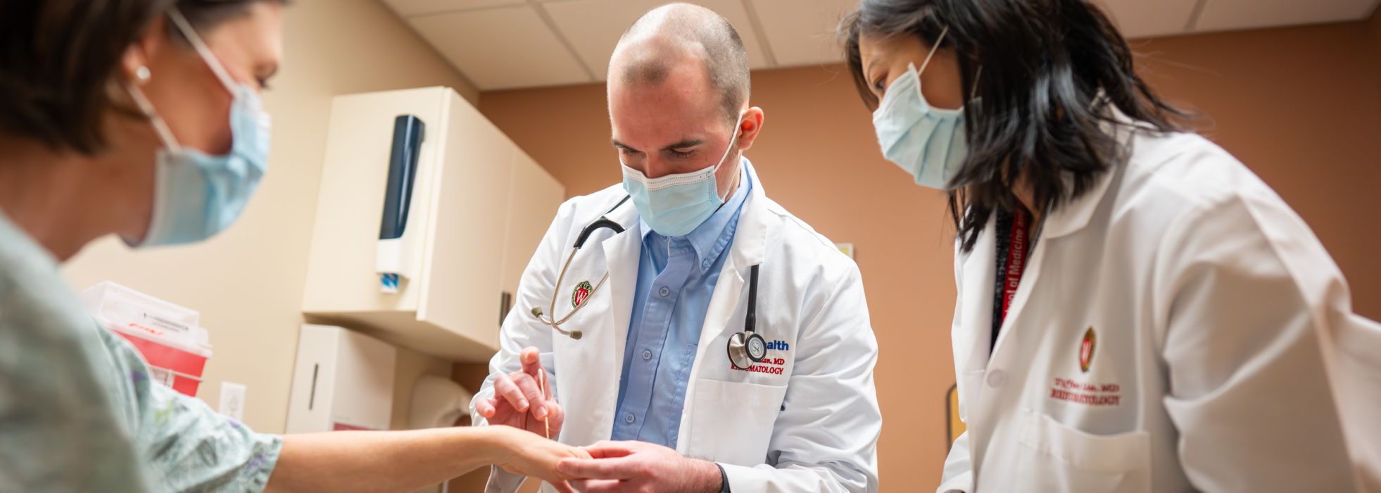 Drs. Tiffany Lin and a rheumatology fellow doing hand exam in clinic