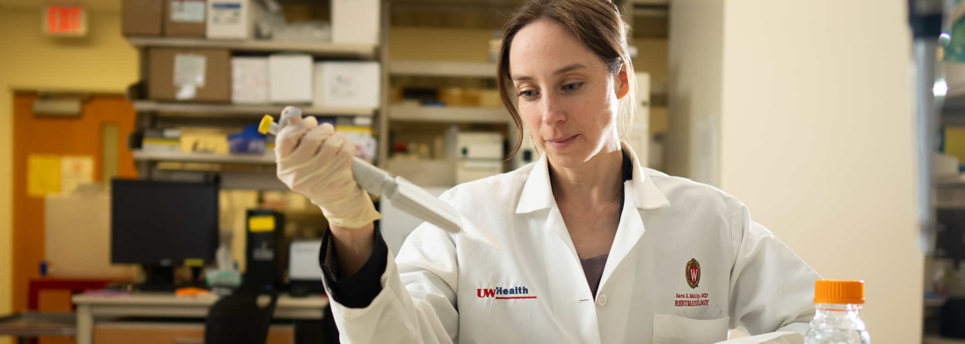 Dr. Sara McCoy in a white coat working in the lab