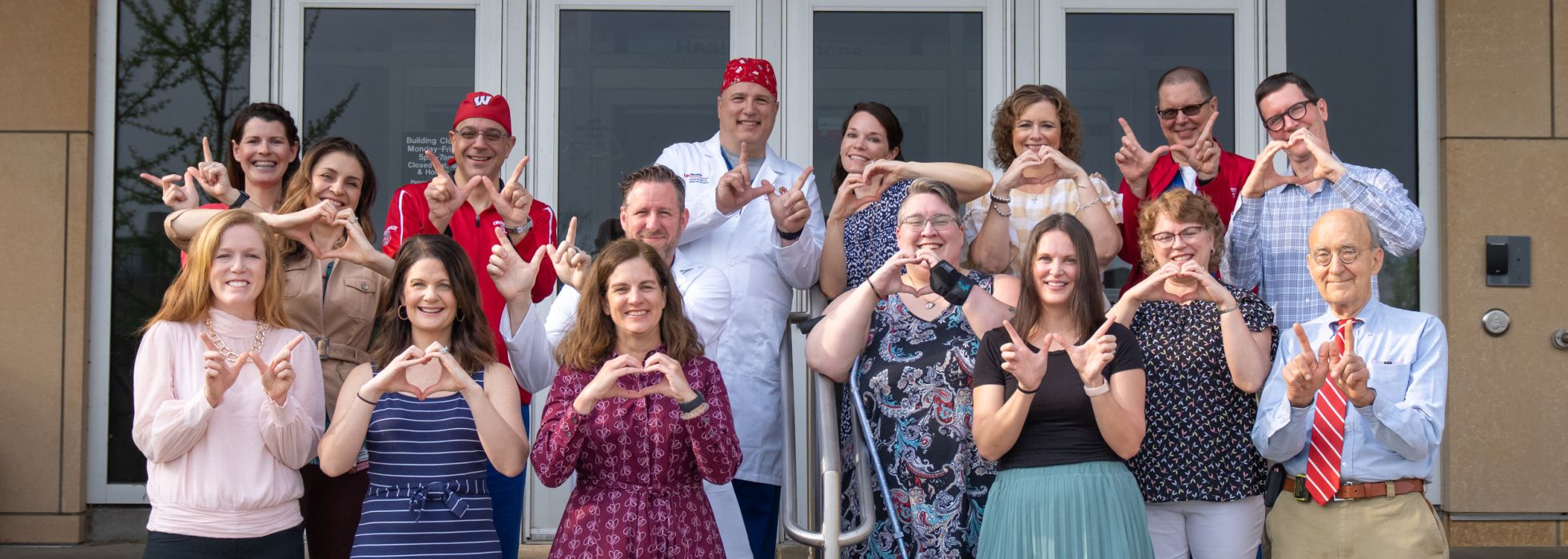 Group photo of congenital heart team making W sign with their hands