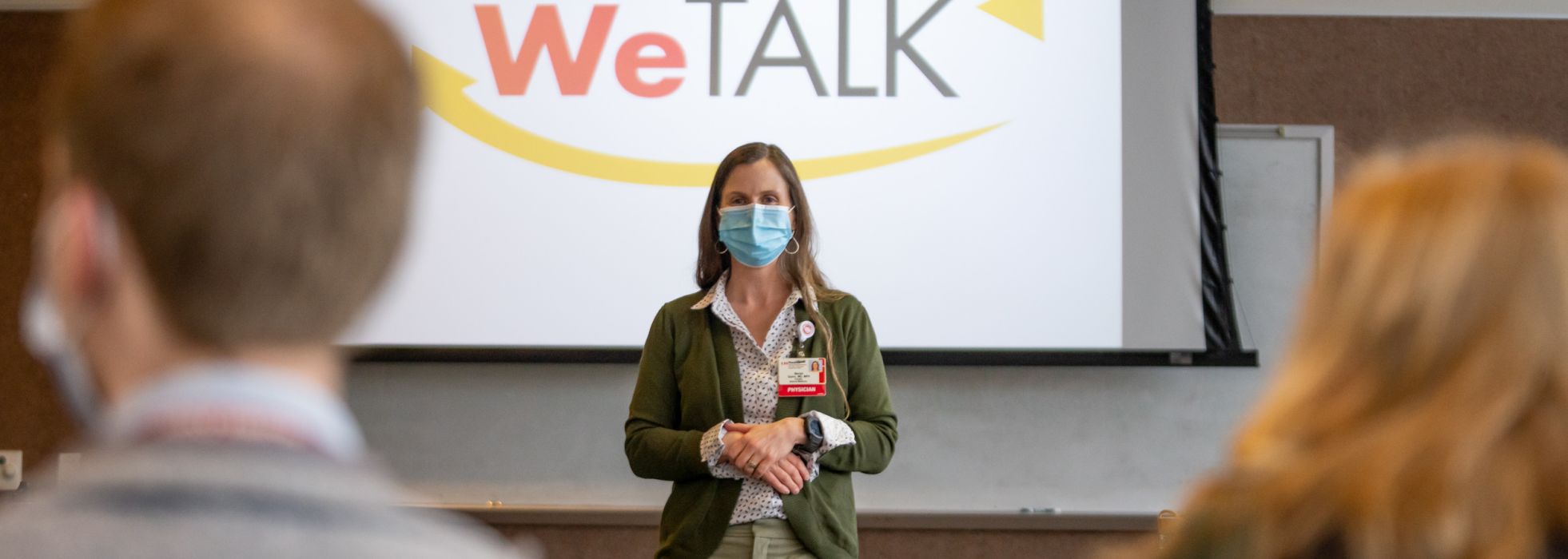 Dr. Mariah Quinn in front of WeTALK slide