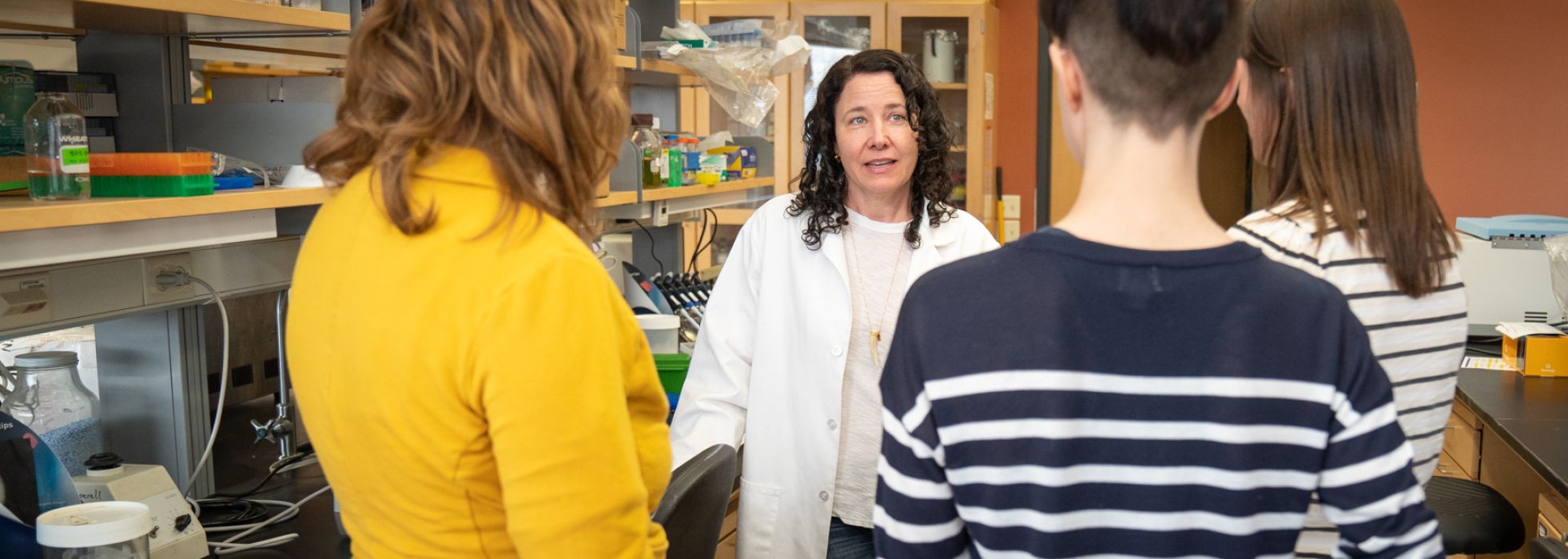 photo of Dr. Caitlin Pepperell mentoring learners in the lab