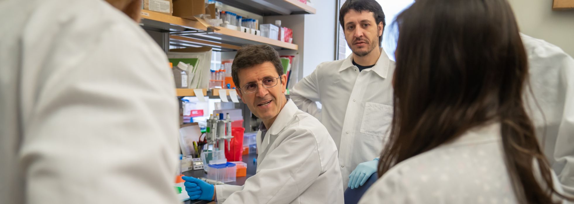 Dr. Luigi Puglielli talks with researchers in the lab