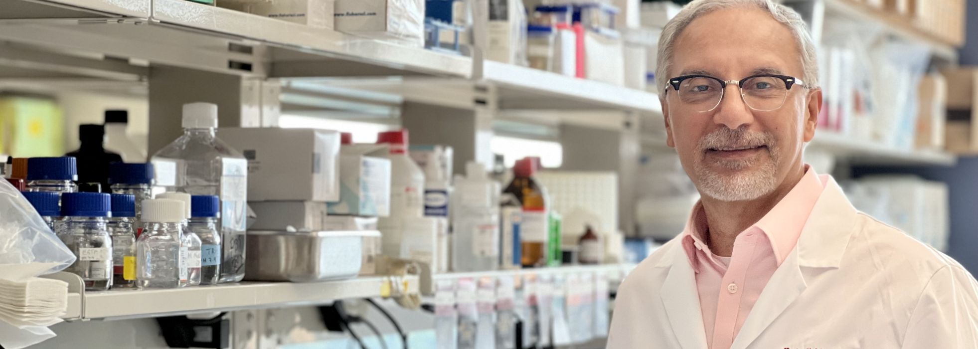 photo of Dr. Hector Valdivia wearing a white lab coat showing an image on the computer screen