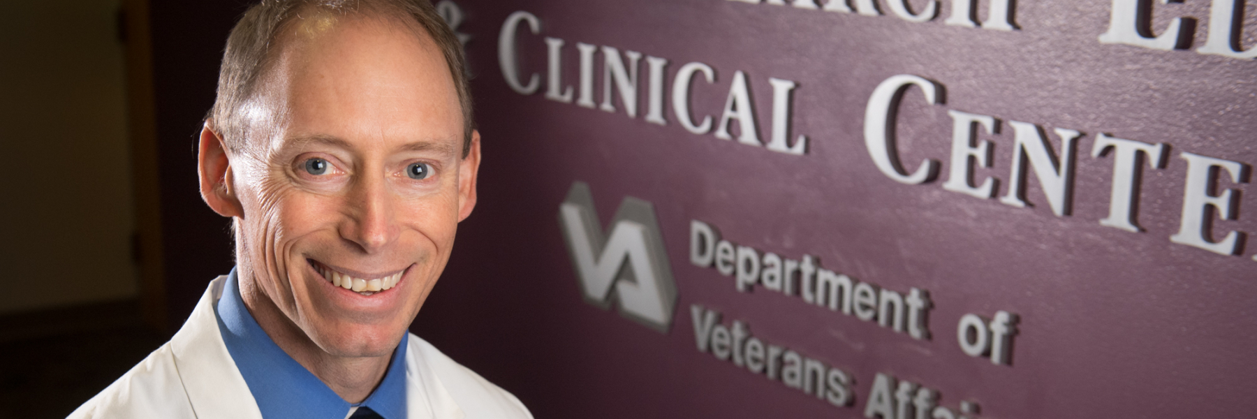 Dr. Steve Barczi in front of the the VA GRECC sign