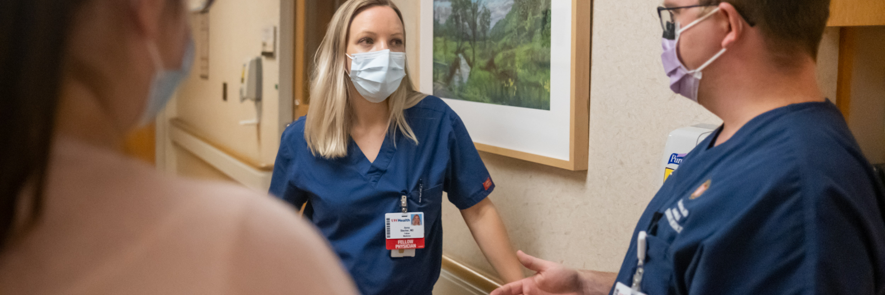Palliative care fellow and faculty talking in a hospital hallway