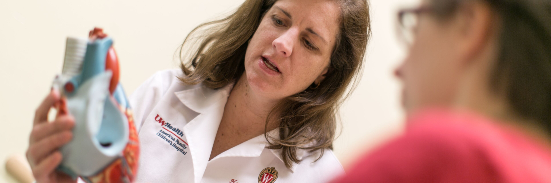 Dr. Heather Bartlett showing heart model to patient