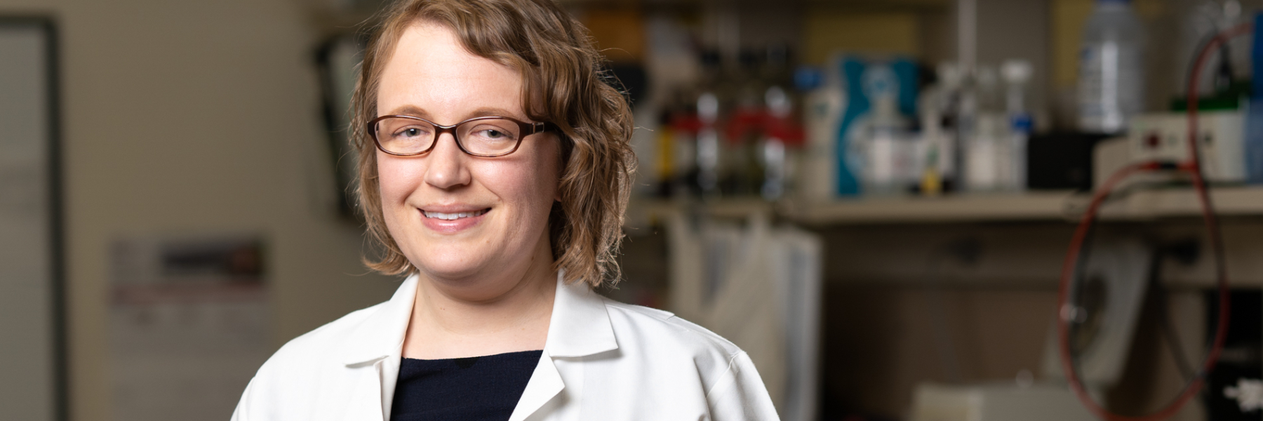 photo of Dr. Sarah Panzer in her lab wearing a white coat