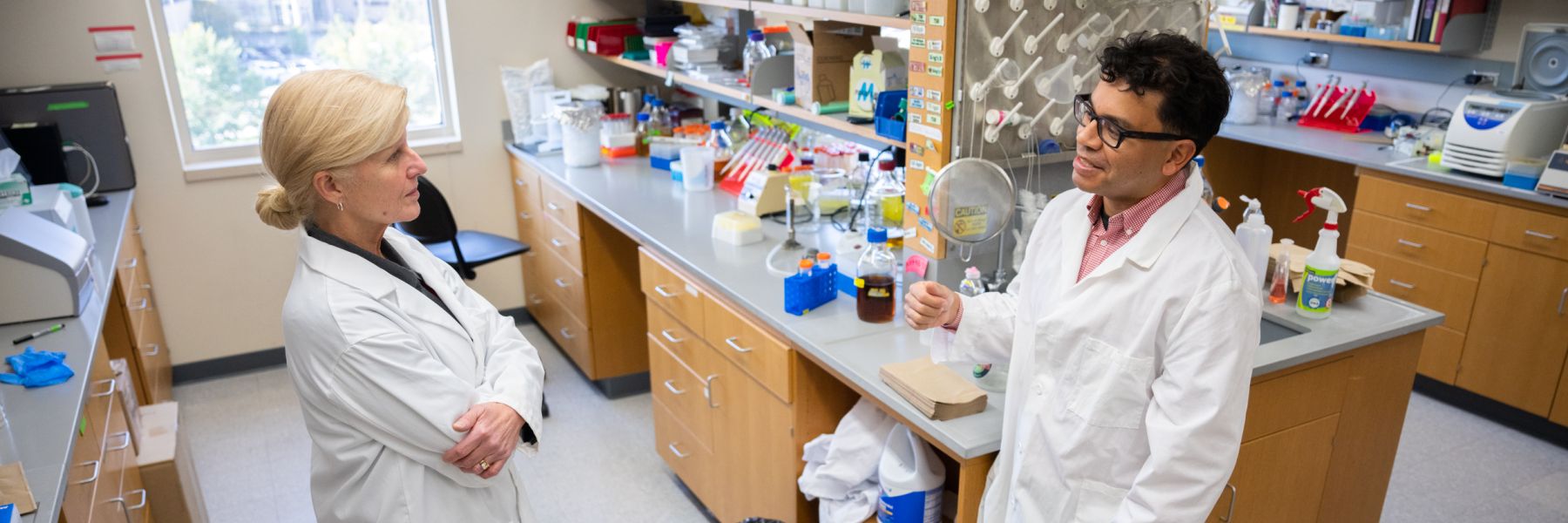 Drs. Mary Hayney and Freddy Caldera talking in the lab