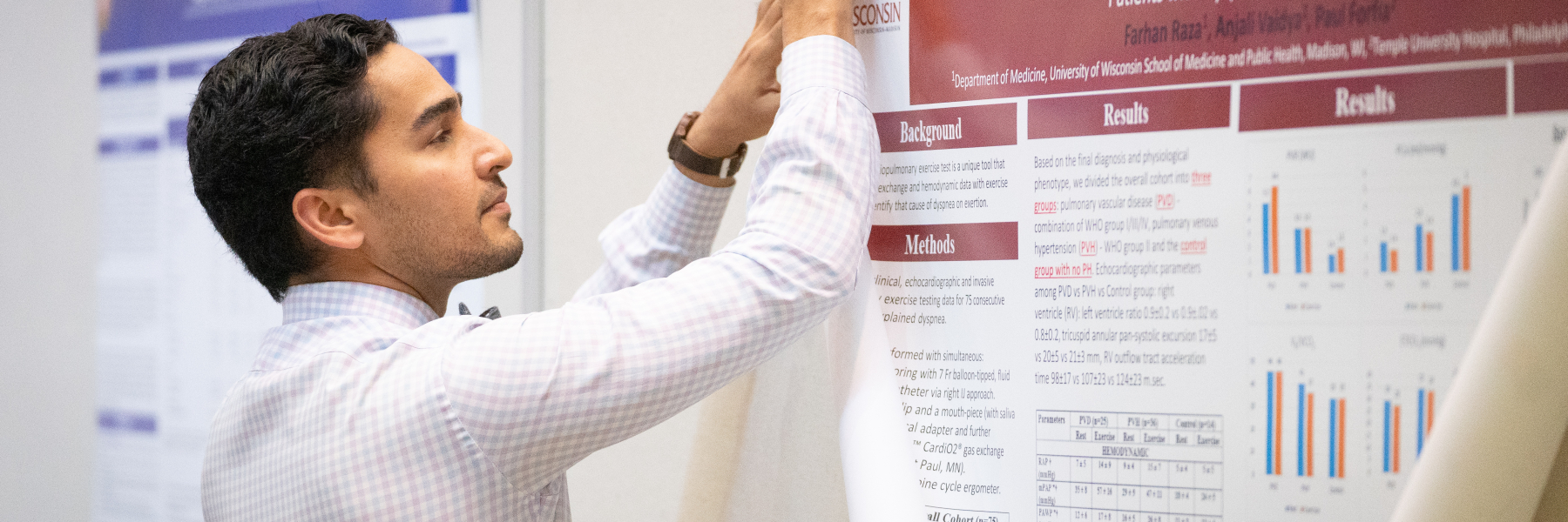 Dr. Farhan Raza pins up his poster on Research Day 2019