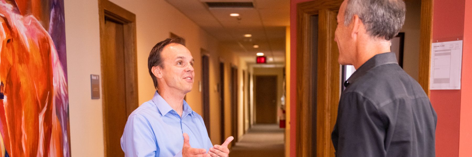photo of Dr. Mark Micek talking to another doctor in the hall