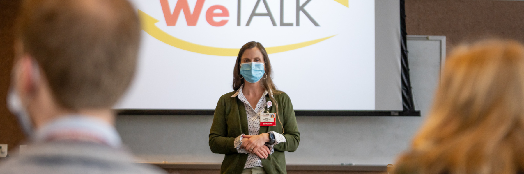 Dr. Mariah Quinn in front of WeTALK slide