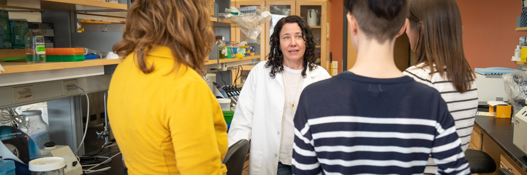 photo of Dr. Caitlin Pepperell mentoring learners in the lab