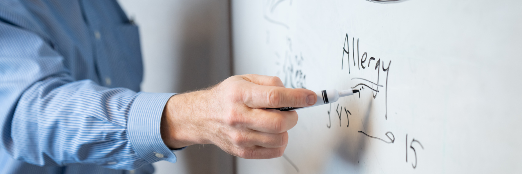 Photo of Dr. James Gern writing on a white board