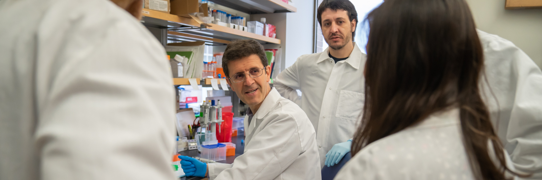 Dr. Luigi Puglielli talks with researchers in the lab