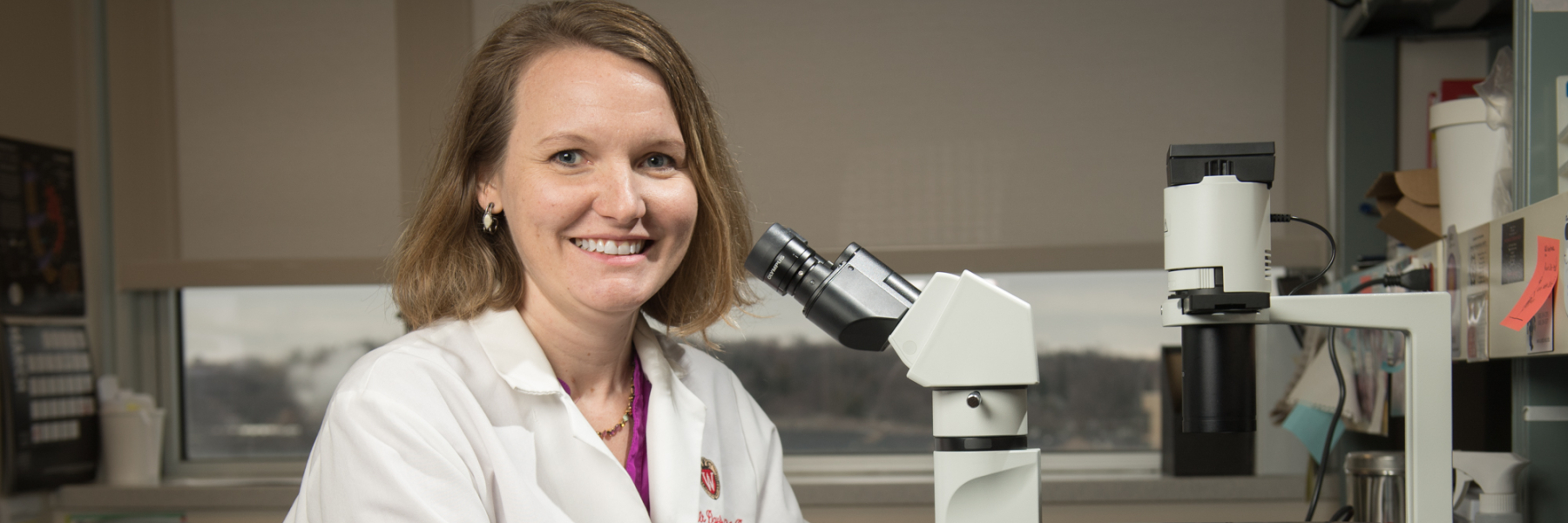 Dr. Dawn Davis in her lab by a microscope