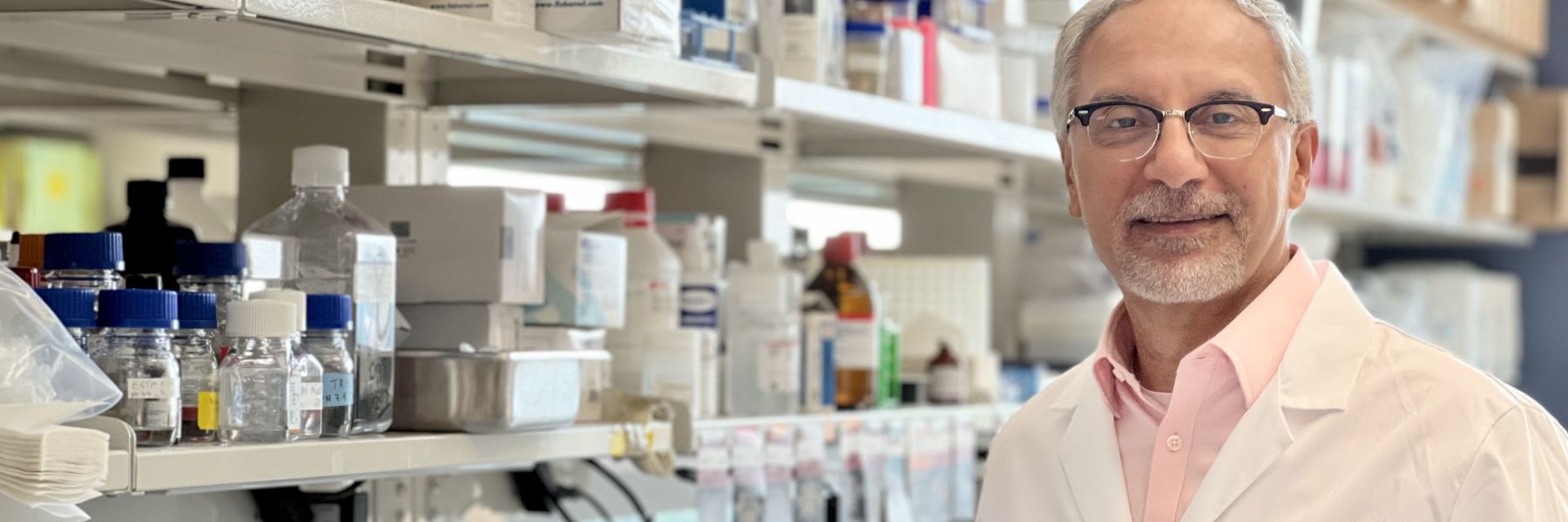 photo of Dr. Hector Valdivia wearing a white lab coat showing an image on the computer screen