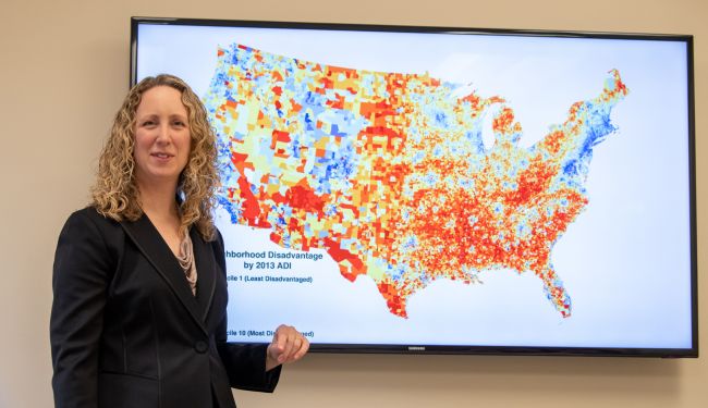 Dr. Amy Kind with a display of the Neighborhood Atlas map. Credit: Clint Thayer/Department of Medicine