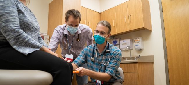 Residency director Andy Coyle, MD, works with Adam Strand, MD, in a clinic