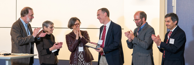 Dr. Loren Denlinger receives a plaque honoring his investiture as the inaugural William W. and Judith H. Busse Endowed Professor in Allergy and Asthma Research. From left: Dr. William Busse; Judith Busse; Dr. Elizabeth (Betsy) Trowbridge; Dr. Loren Denlinger; SMPH Dean Dr. Robert N. Golden; Dr. Nizar Jarjour.