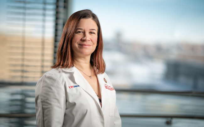 Kari Wisinski, MD, stands wearing a white coat