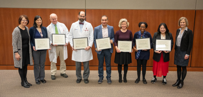 Photo of the 2023 DOM Education Award winners, left to right, between department chair Lynn Schnapp, MD (far left) and Laura Zakowski, MD (far right): Tiffany Lin, MD; Mark Reichelderfer, MD; Zachary Goldberger, MD, MS; Sandesh Parajuli, MD; Laurel Romer, MD; Christine Sharkey, MD; Andrea Schnell, MD.