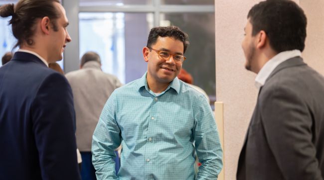 Dr. Caldera talking to two men in suits.