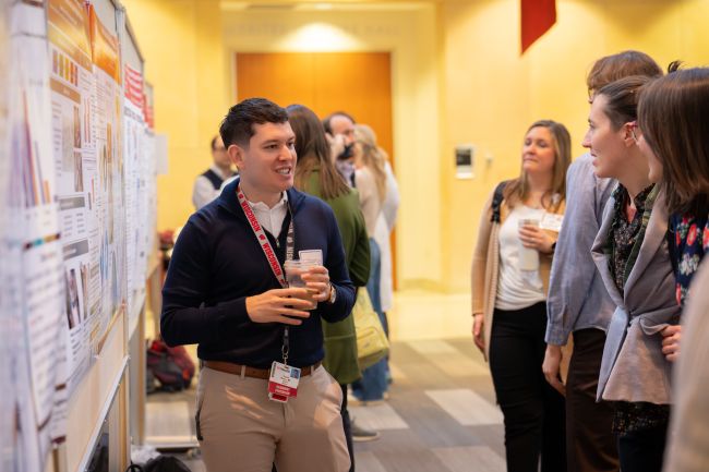 Gabe Moreno explains his poster to onlookers.