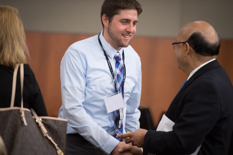 Adam Gepner shaking hands with a man at a conference