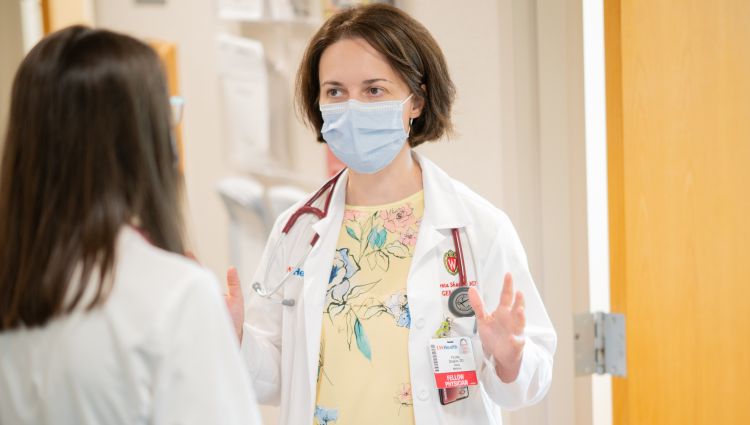 Geriatrics fellow and faculty member talking in a hospital hallway