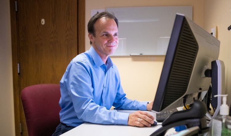 photo of Dr. Mark Micek working at the computer in his office