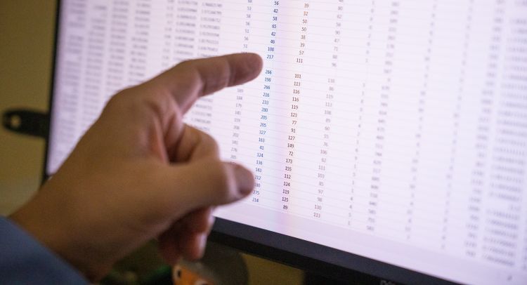 photo of Dr. Mark Micek's hand pointing at data on computer screen