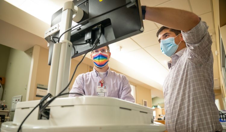 photo of Dr. Peter Kleinschmidt and colleague working at a portable computer