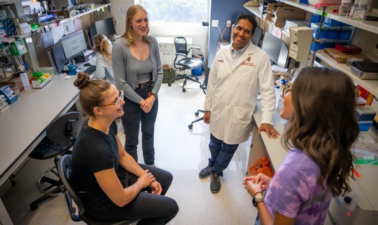 photo of Dr. Mohan Ramratnan talking with research team