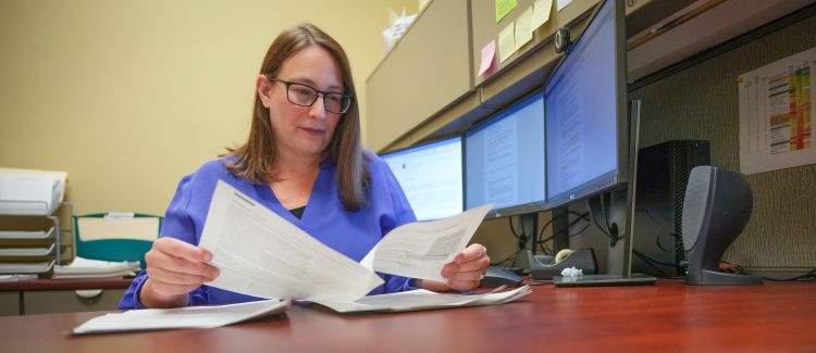 photo of Dr. Jen Weiss looking at papers in her office