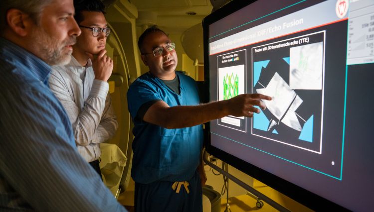 Medical student and Shapiro Summer Research Program participant Jonathan Le (center), along with co-mentors Michael Speidel, PhD (left), and Amish Raval, MD (right), evaluate ways to potentially combine x-ray fluoroscopy and ultrasound imaging for interventional cardiology procedures.