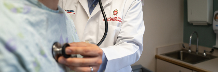 A doctor checks a patient's heartbeat.