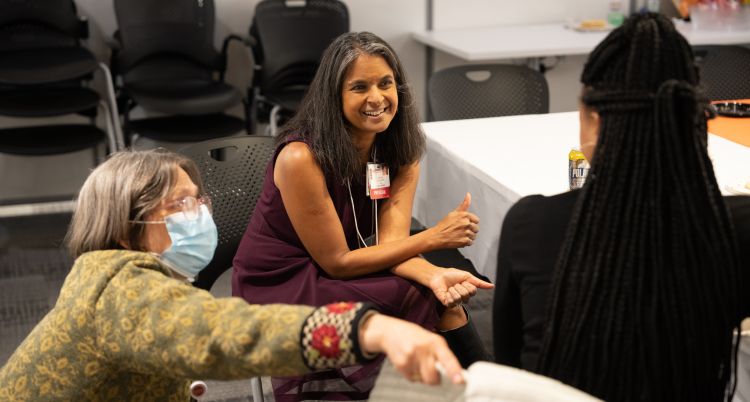 Drs. Betsy Trowbridge and Shobhi Chheda talking with participant at DOM URM social event