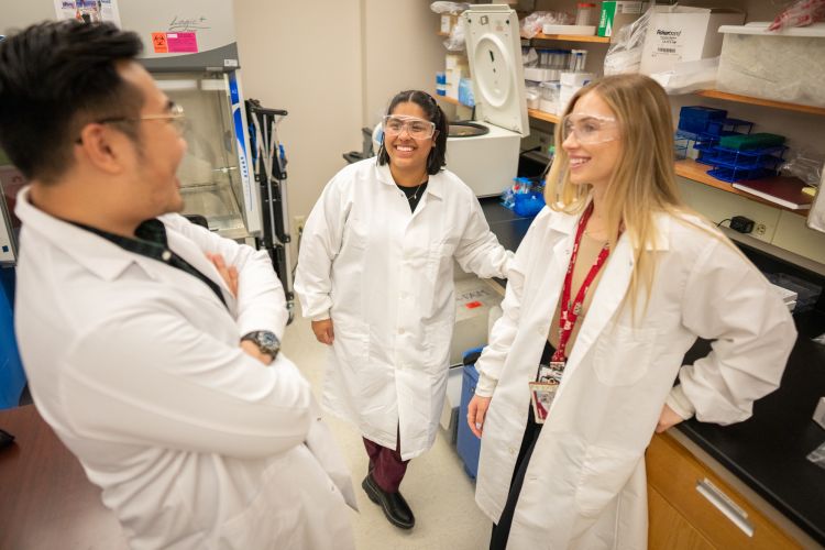 Dr. Cindy Carlsson's research team talking in the lab