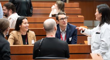 DOM faculty and learners chatting before the Education Day Grand Rounds.